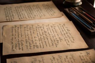 Feuillets de manuscrit annotes poses sur un bureau de travail